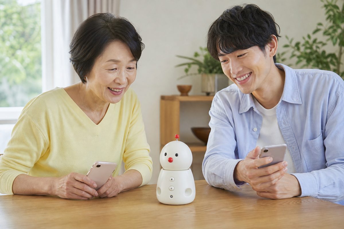 家族でスマホを見ながらロボットを囲む
